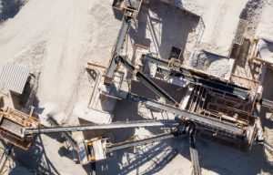 Aerial view of an industrial site showing machinery and equipment for processing materials, highlighting engineering infrastructure involved in mining or aggregate production. This image represents the capabilities of engineering firms like Vista Projects.