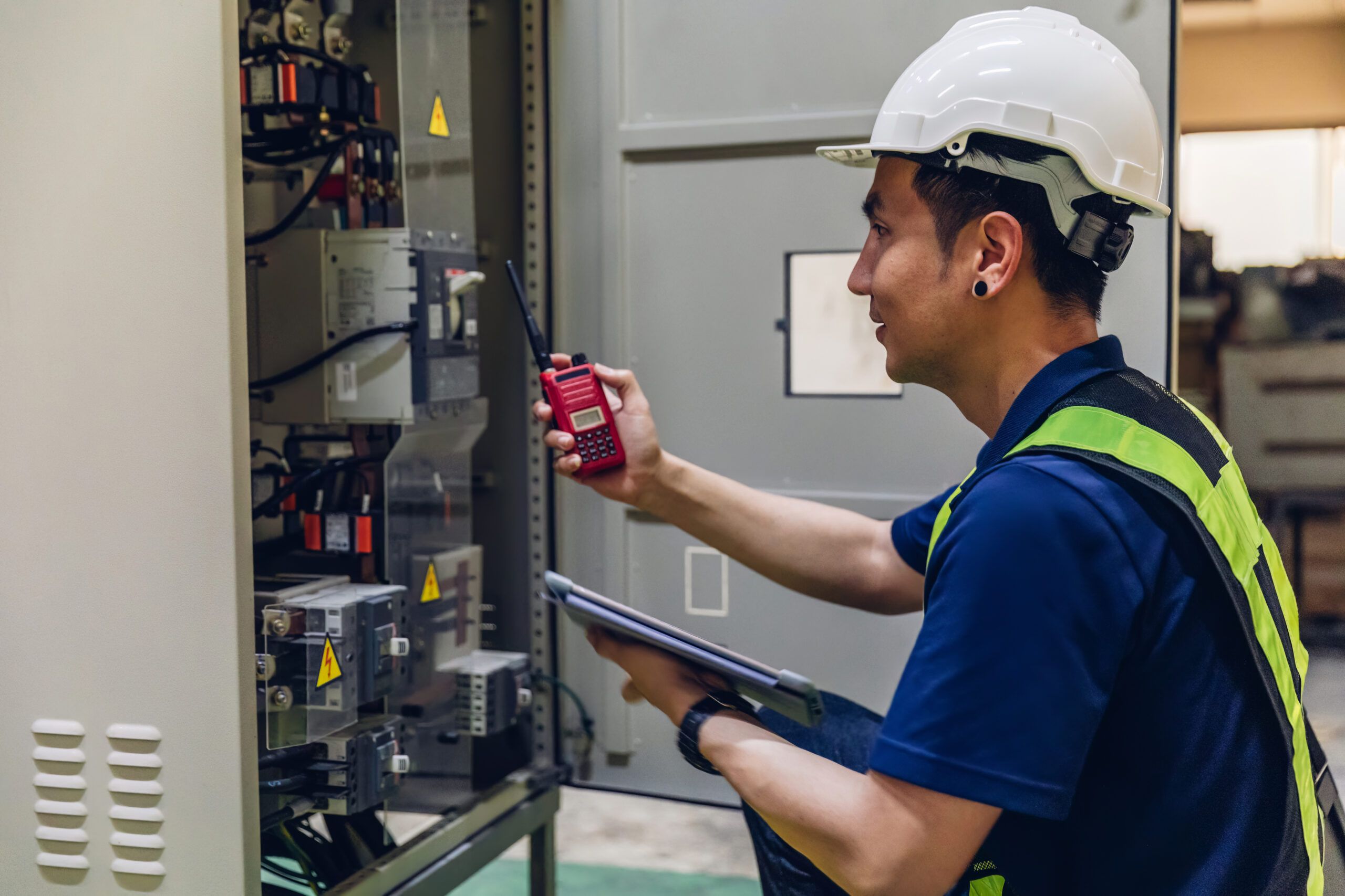 Electrical engineer working in a control room, monitoring voltage levels and system performance.