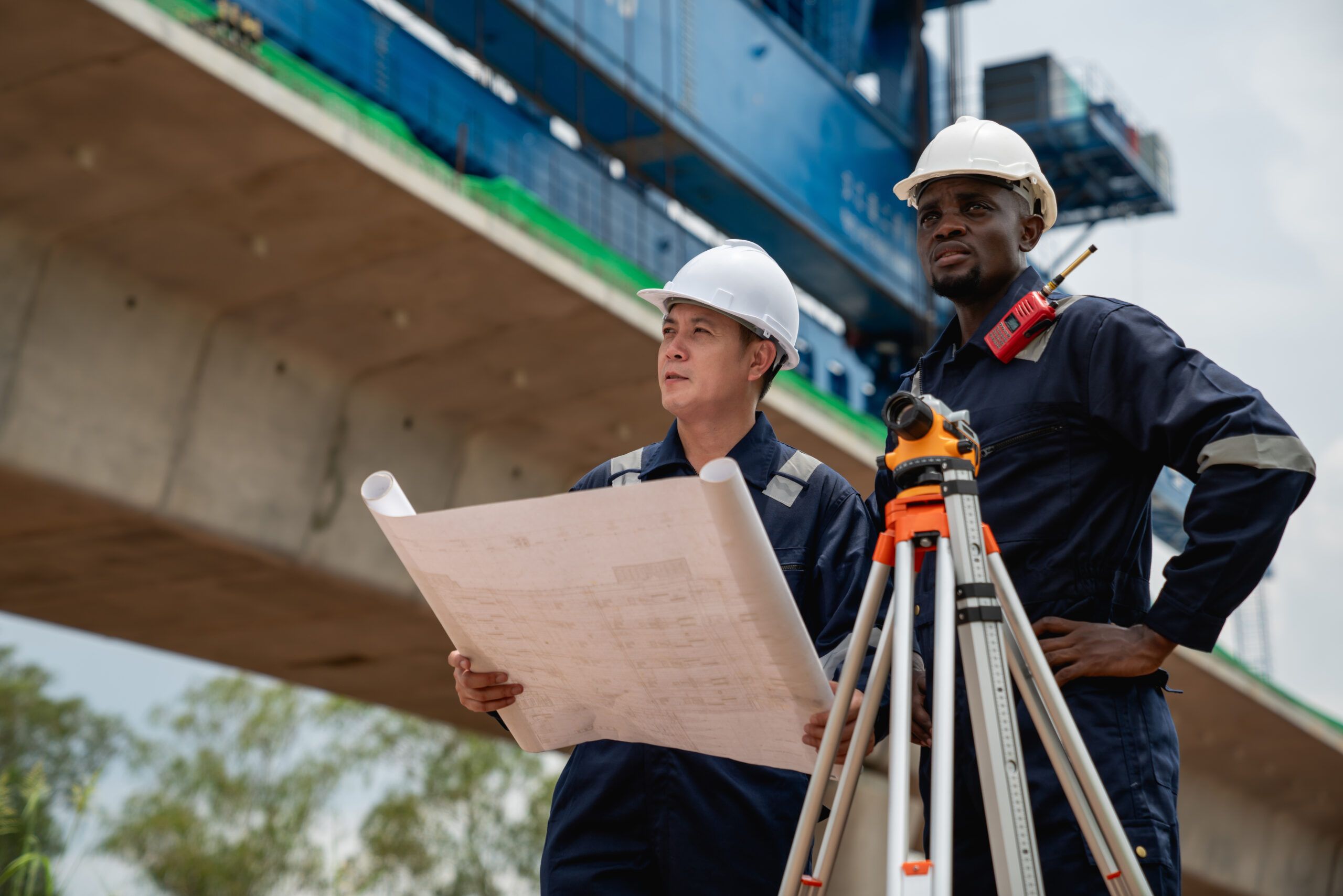 Survey team of civil and structural engineers using a theodolite on an infrastructure project, reflecting modern engineering practices.