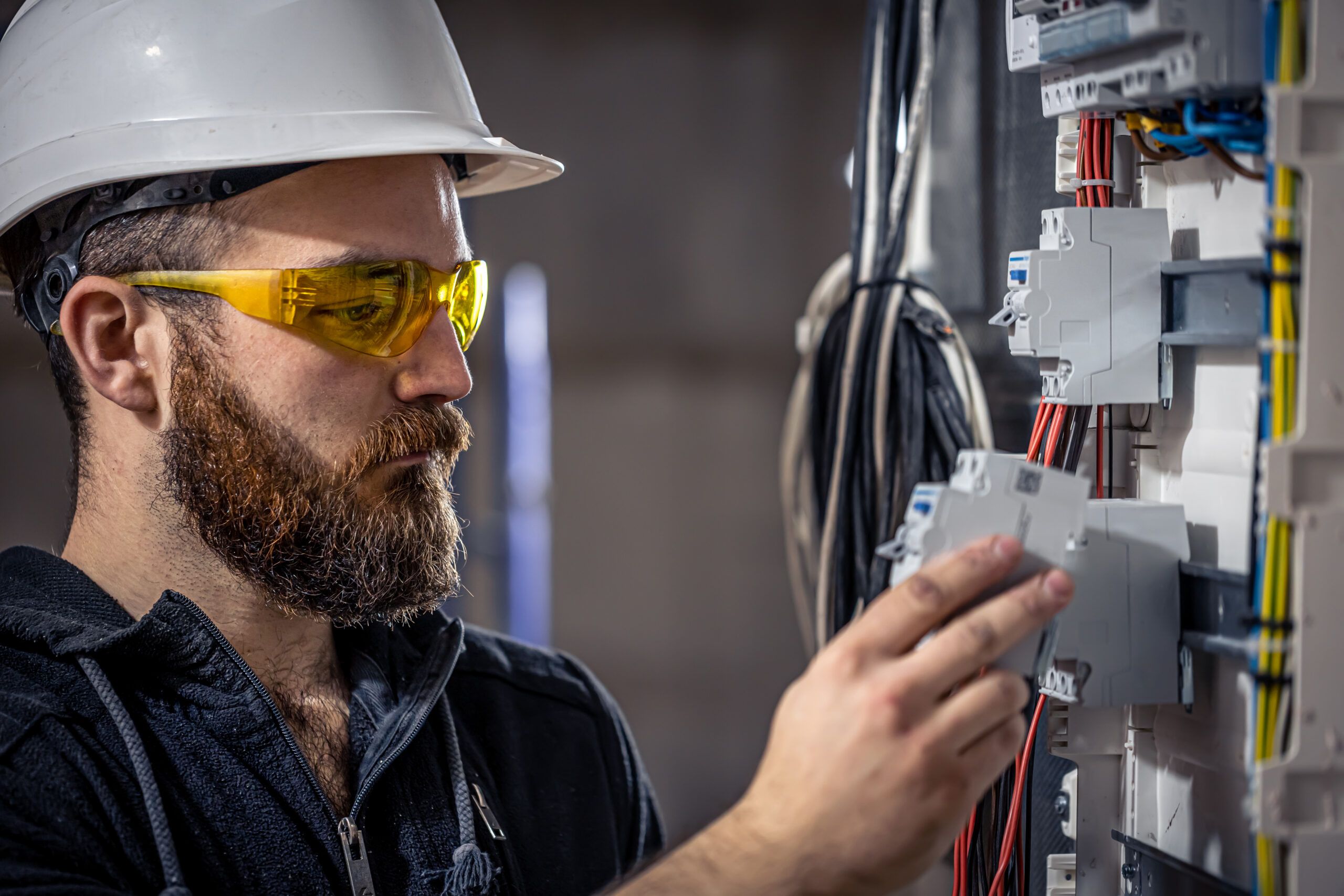 Electrician working on a switchboard, representing electrical engineers in the evolving job market, including renewable energy and automation.