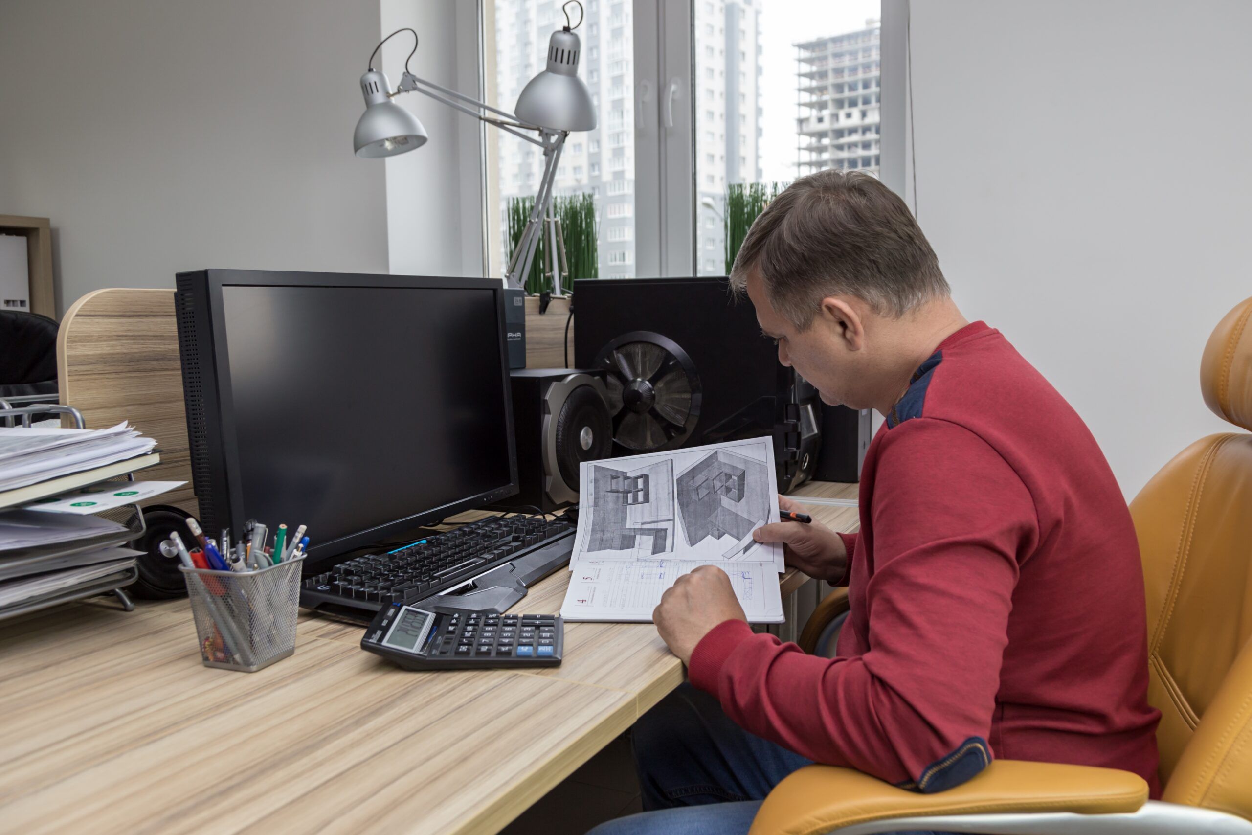 Professional workspace with engineer analyzing mechanical design portfolio